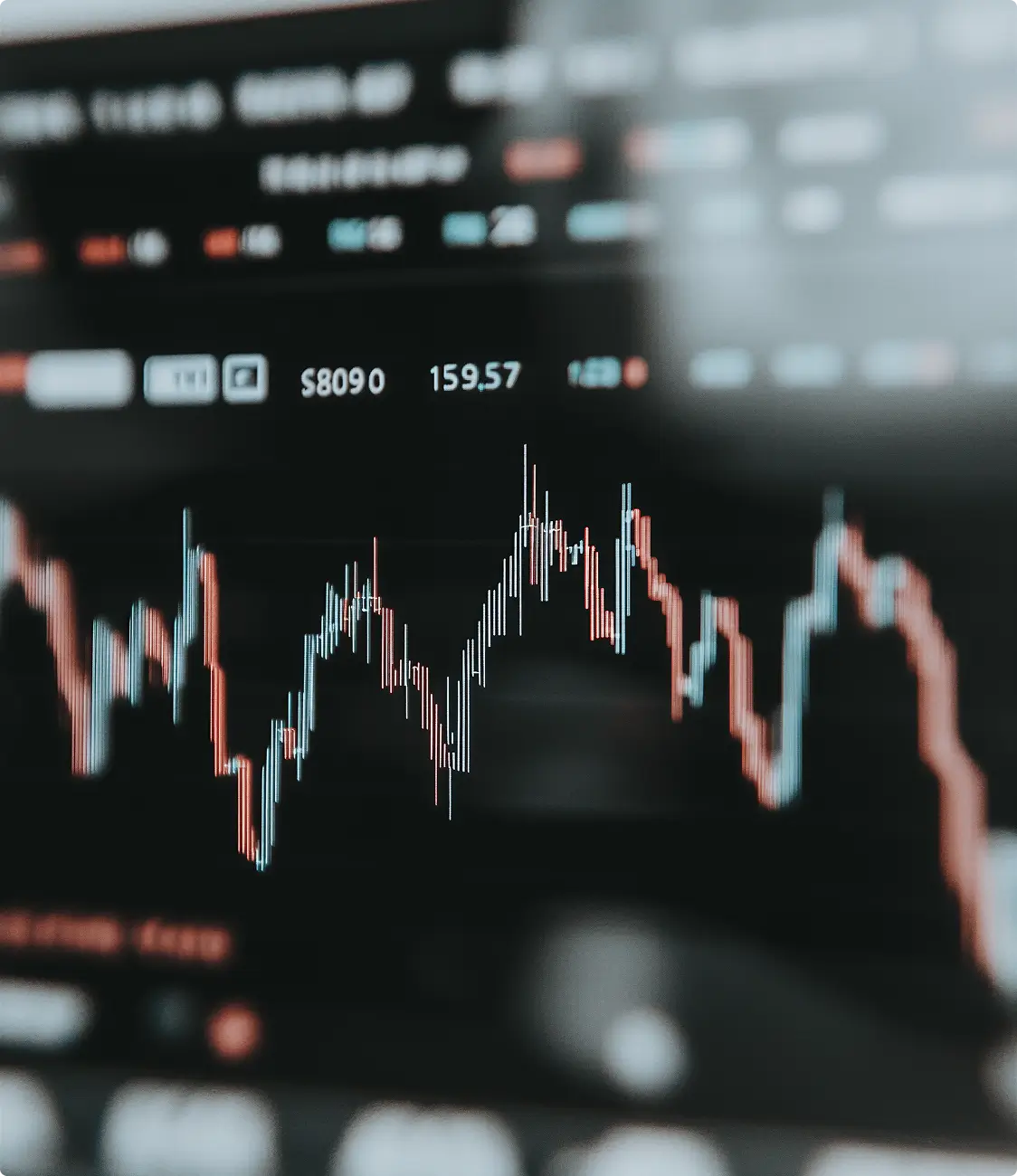 Close-up of a digital stock trading chart displaying red and blue candlestick patterns and numerical data on a dark background.